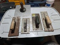 Group shot of four trowels and plaster hawk