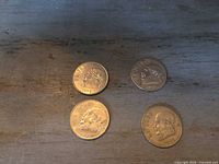 Four 1 Peso coins laid out obverse up