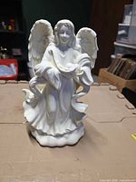 Front view of white resin angel figurine candle holder