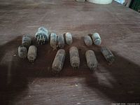Top view of 13 miniature glass vacuum tubes on wooden surface