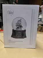 Front of original Precious Moments box showing snow globe image and branding