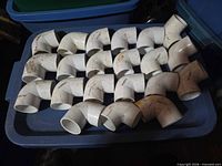 All 18 PVC elbows laid out on blue tote