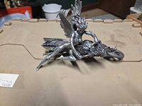 full view of silver resin angel figurine riding motorcycle
