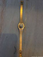 Full view of watch front showing mesh bracelet and dial