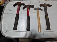 All four claw hammers lined up on a bin lid