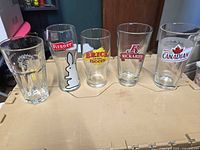 Front view of all five branded pint glasses