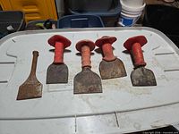 Five cold chisels on plastic lid for overview