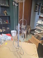 Full view of assembled wind chime hanging, showing chains, rings with figures, center tube