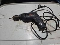 Full view of Talon hammer drill with cord on lid