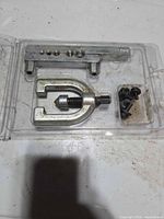 Kit components arranged in opened blister: flaring bar, yoke, adapters