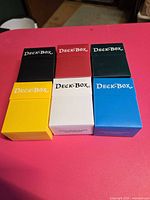 Front view of six Ultra PRO deck boxes in assorted colors
