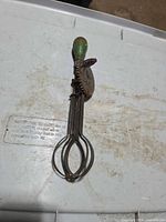 Full view of egg beater showing handle, gear and beaters