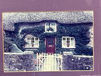 Close view of photograph showing thatched-roof cottage details