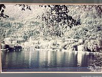Close view of photograph showing lakeside houses and water reflection