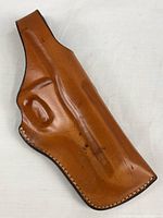 Front view of tan leather holster showing molded shape and stitching