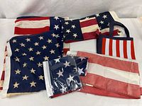 Group view of four unfolded flags, two packaged flags, and tote bag