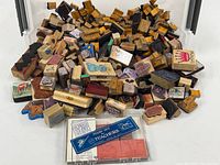 Overview of entire lot showing large quantity of wood-mounted rubber stamps and plastic cased stamp kit