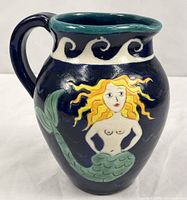 Full left side of pitcher showing mermaid image and overall form