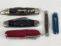 Group view of five pocket knives and multi-tools