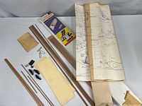 Overview of kit contents including wood spars, balsa sheet, rubber bands, plastic parts and plans