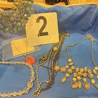 Group shot of all five necklaces on blue cloth