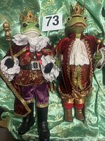 Both frog prince figures standing side by side showing full outfits and size tag