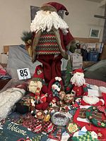 Group shot showing tall Santa doll, ornaments, stockings, banner, sign