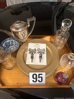 Overview of lot on tray showing coffee pot, decanters, perfume bottle, bowl, charger plate, wine stoppers