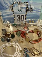 Full layout of necklaces, rings, bracelet and multiple earrings displayed on two acrylic stands
