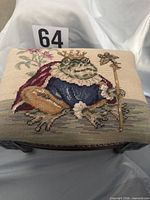 Top view showing Frog Prince needlepoint upholstery and overall stool shape