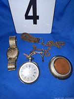 Overall view of both timepieces, chain, key, leather fob, detached back cover
