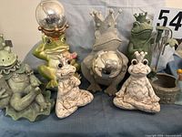 Group shot of all frog statues, wishing well and chimes