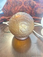Amber embossed glass globe shade on table