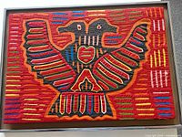 Front view of framed Kuna mola showing entire bird design