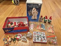 Full lot overview showing boxed Santa, open shoe box of ornaments, blister pack of mini ornaments, beaded balls, mushroom set, angels, gnomes, Santa candle holder