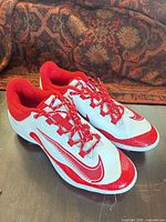 Side view of both Nike cleats showing color, design and condition