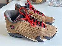 Side view of both sneakers showing color, material and condition