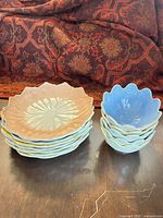Stack of pastel leaf plates beside stack of pastel flower bowls