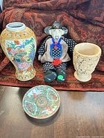 Group shot of all four items: vase, saucer, doll, carved cup