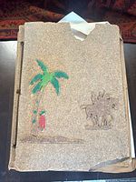 Front cover with cork surface, palm tree motif and missing top section