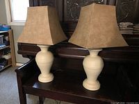 Front view of both matching lamps showing urn bases and square shades