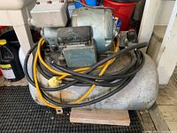 Overall view of air compressor showing tank, motor, pump, power cord and fittings