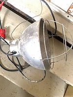 Side view of aluminum heat lamp showing reflector dome, wire guard and cord