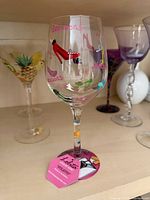 Front view of Lolita Stiletto wine glass showing painted shoe motifs and tag