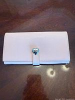 Front of pink leather wallet showing heart clasp