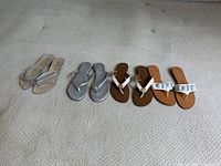 All three sandal pairs side by side on carpet