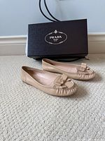 Pair of beige Prada leather ballet flats with box shown behind