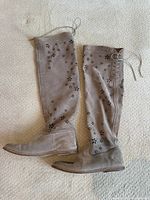 Full view of both boots lying flat showing shafts with cutout pattern