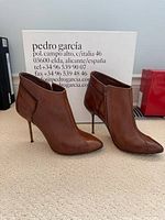 Pair of brown perforated leather ankle boots with box background