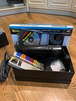 Box containing power bar, slim media player, round device and Premiere Audio/Video Care Kit